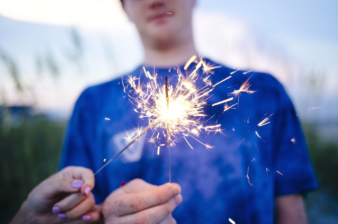 Bild von junger Person mit Wunderkerze in der Hand 