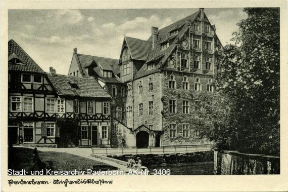 Schwarz-Weiß-Foto, das links ein Fachwerkhaus und rechts ein fünfstöckiges Gebäude zeigt.