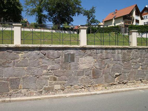 Fernansicht der Feldsteinmauer mit der Gedenktafel