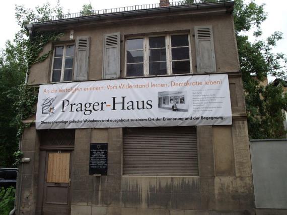 Frontansicht des Prager-Hauses mit Werbebanner an der Fassade