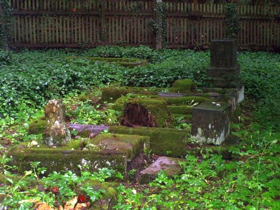 four graves, overgrown with moss and ivy