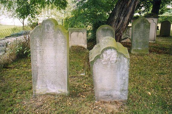 large gravestones with inscriptions, the right one is crooked