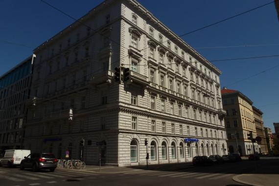 Six-storey residential building on the street corner with a sandstone facade