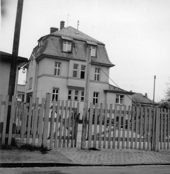 Schwarz-Weiß-Foto des dreistöckigen Gebäude mit kleinem Anbau im Erdgeschoss