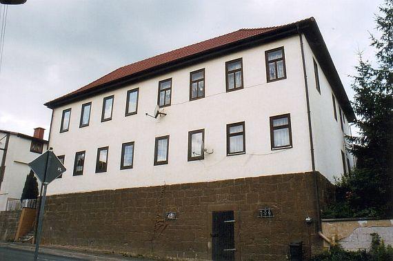 Frontansicht des Hauses, zwei Fensterreihen in den Obergeschossen mit je acht Fenstern