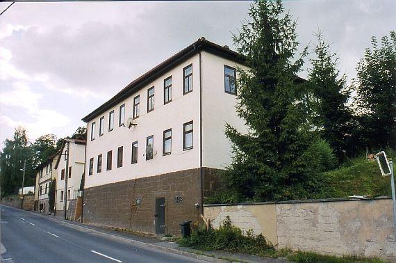 white building on a street with a steep slope