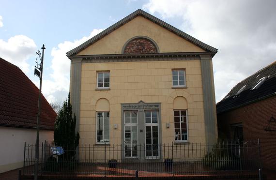 Die gelbe Synagoge wird von zwei in die Fassade eingelassenen Säulen eingerahmt. Im Giebel ist ein Halbkreis, darin ein Davidstern.