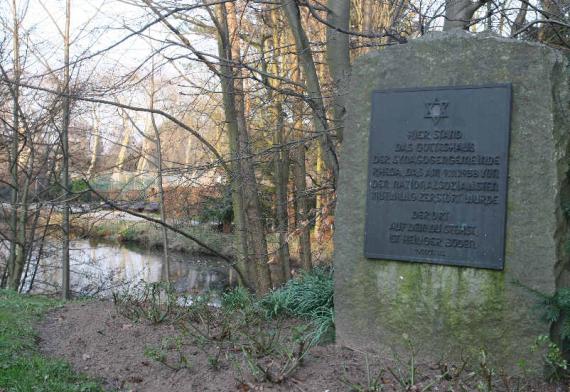 Inschrift des Gedenksteins: "Hier stand das Gotteshaus der Synagogengemeinde Rheda, das am 9.11.1938 von den Nationalsozialisten mutwillig zerstört wurde. Der Ort auf dem du stehst, ist heiliger Boden."