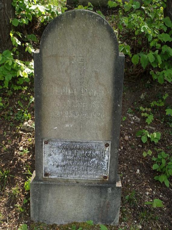 weathered gravestone with plaque on it