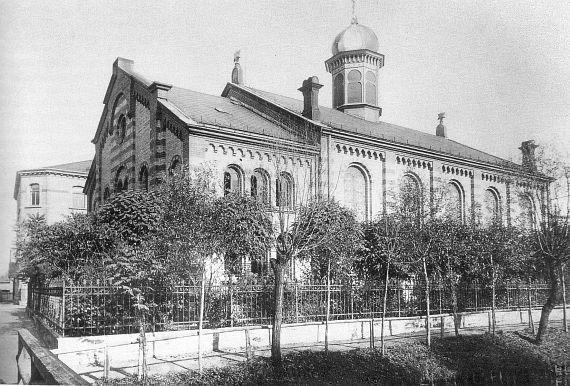 Black and white photo: large synagogue with decorative elements on the facade and a tower in the center