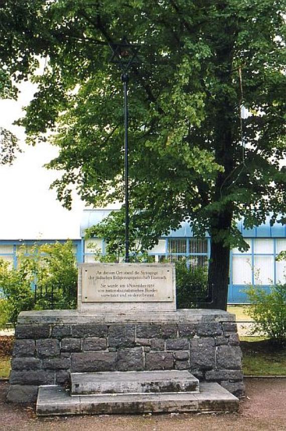 Wall, on it two steps leading to the memorial plaque