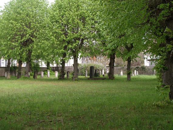 front lawn, behind gravestones and deciduous trees