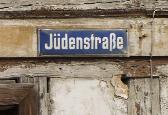 blau, Aufschrift: Jüdenstraße; auf Holz, von dem der Lack blättert