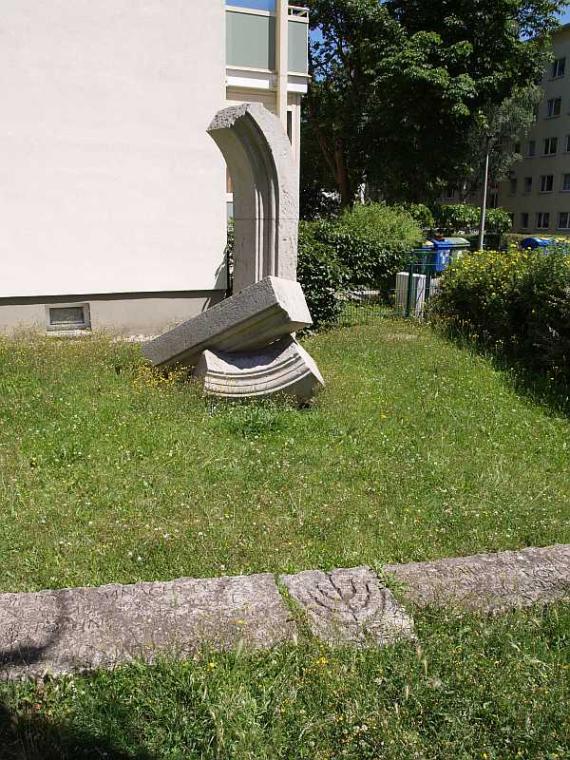 Parts of a stone arch laid one on top of the other on a grassy area