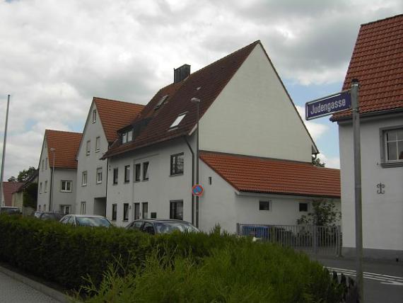 A row of white houses with red roofs on the right side of the street