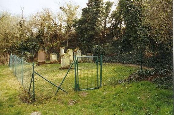 mit Maschendrahtzaun umzäunter Friedhof