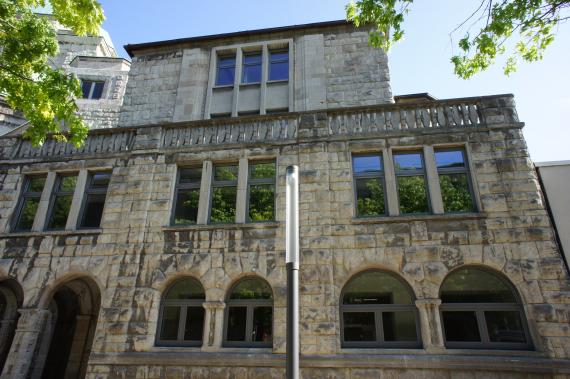 View of the stone facade of the house with arched windows on the first floor