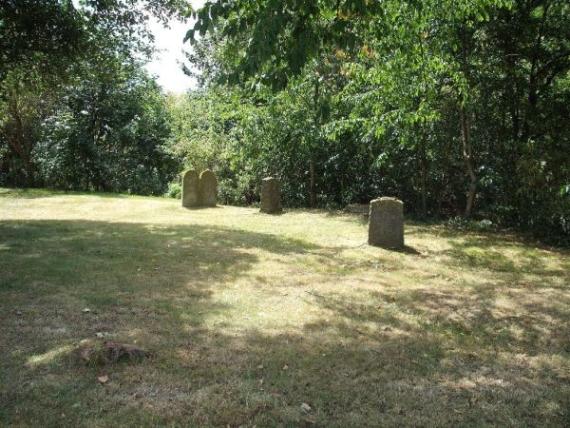 some gravestones on meadow with trees