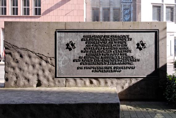 Back of the memorial plaque with two Stars of David and inscription: "Here stood the synagogue of the Jewish community of Düsseldorf. It became a victim of racial mania on 9 November 1938. Of the proud community, only 58 Jewish citizens returned from 5053. To the dead in honorable memory, to the living as a reminder. The Municipality of Düsseldorf November 9, 1946."