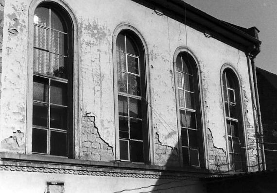 Vier Rundbogenfenster einer heruntergekommenen Hausfassade