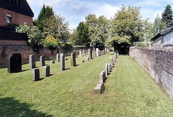 three rows of gravestones surrounded by a wall