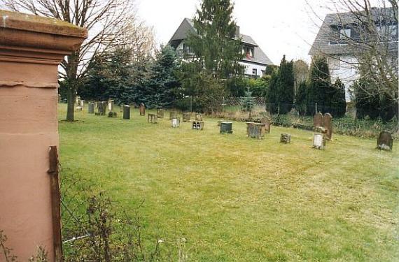 Lawn with gravestones, behind it residential houses