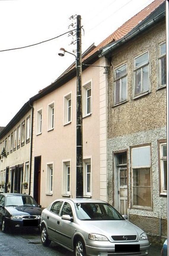 Row of houses, rear house yellow, center same, front rough, gray plastered