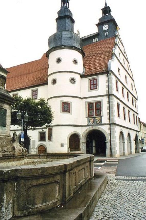 stone fountain in front of the town hall with turret