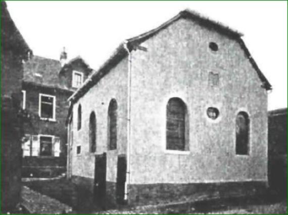 black and white shot of old big building with two windows in front