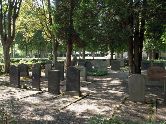 Shady gravel paths with several tombstones and trees