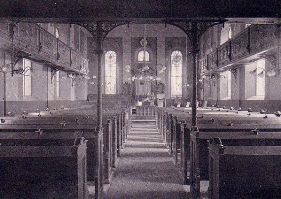 Interior of a prayer hall with many rows of wooden benches