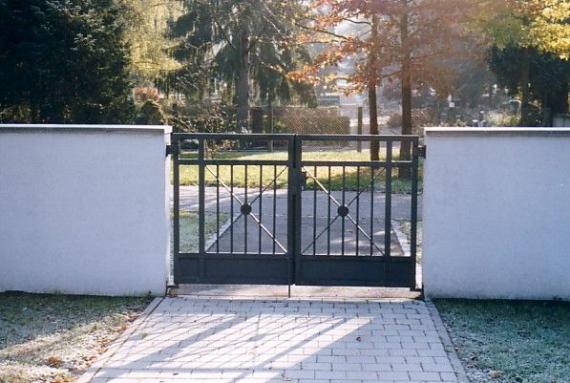 Half-high wall, black metal entrance gate between them