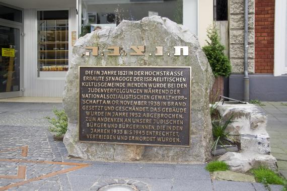 großer Stein mit einer Gedenktafel mit goldenen Lettern