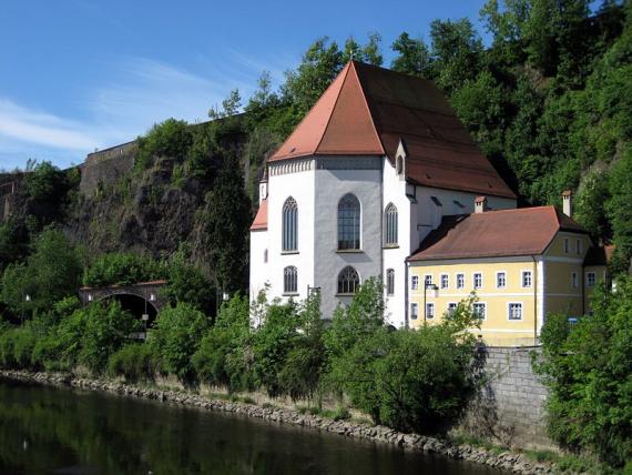 Großes weißes Haus mit roten Dächern an der Donau