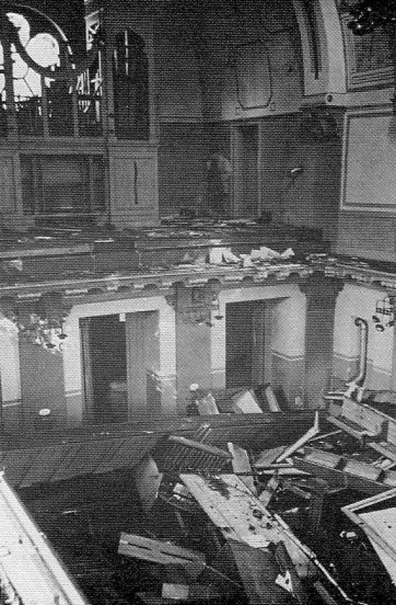 Destroyed interior of a large church, broken pews and windows