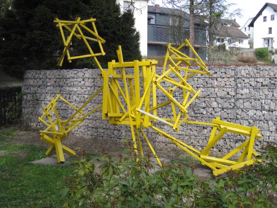 "Diaspora" sculpture by artist Dan Richter-Levin consists of steel sculpture painted yellow and is placed along the cemetery wall