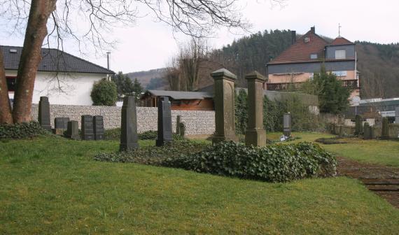 dark gravestones on hilly lawn