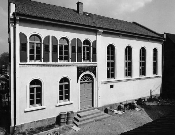 Black and white picture, view of a house front with many round arch windows