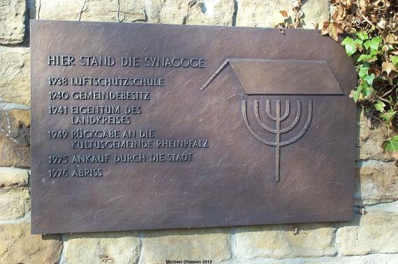 "Hier stand die Synagoge   1938 Luftschutzschule - 1940 Gemeindebesitz - 1941 Eigentum des Landkreises - 1949  Rückgabe an die Kultusgemeinde Rheinpfalz - 1975 Ankauf durch die Stadt  1976 Abriss"