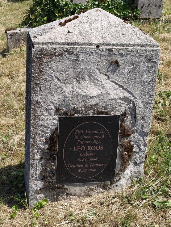 weathered gravestone with newly mounted plaque