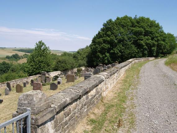 weathered, situated on a slope, on the right a road