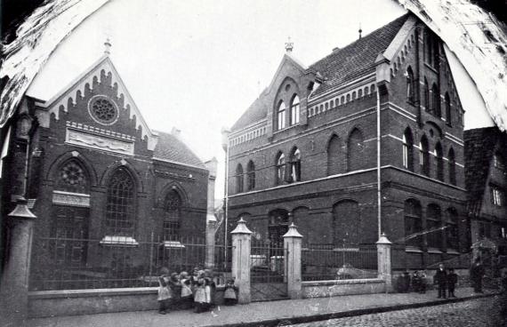 schwarz weiß Fotografie von zwei Häusern mit spitzen Dächern und bogenförmigen Fenstern