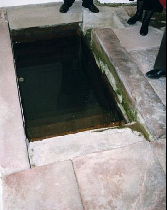 Rechteckiges Wasserloch in einem Steinfußboden eines Hauses