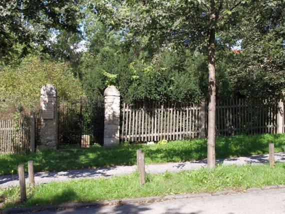 Close-up of the wrought iron gate, on the left a memorial plaque