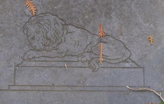 Engraved on a stone: image of a lion sitting on a coffin