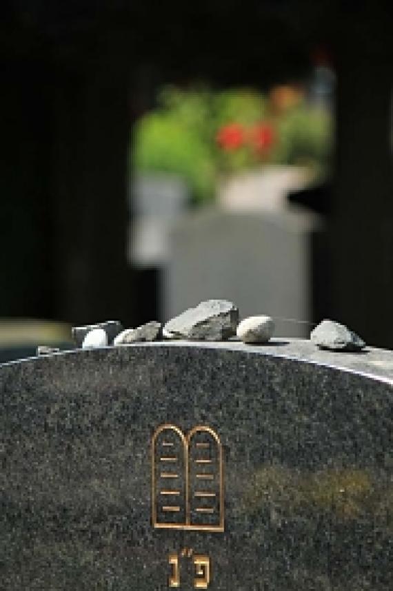 Upper part of Jewish gravestone with small stones on it