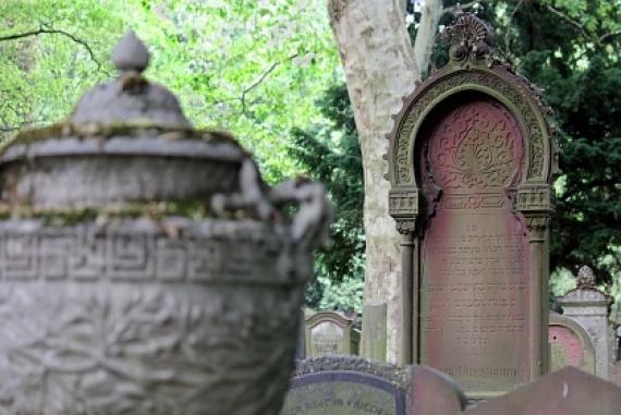 Old gravestone with Hebrew inscription, in the foreground stone urn