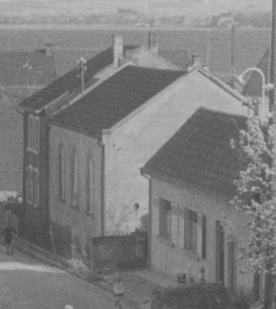 black and white picture of the street where the synagogue stood. Centered house on the right with large windows.