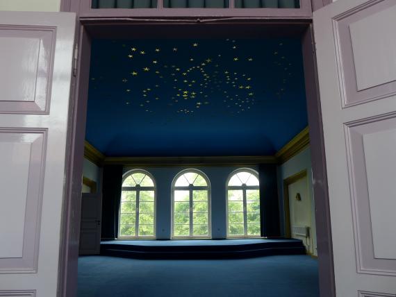 Interior view of blue painted room decorated with golden stars on the ceiling.