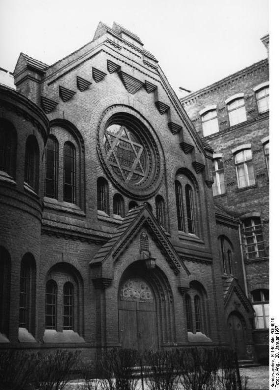 black and white picture of the building. Large house with wooden door and and a round window in the center above with a Star of David